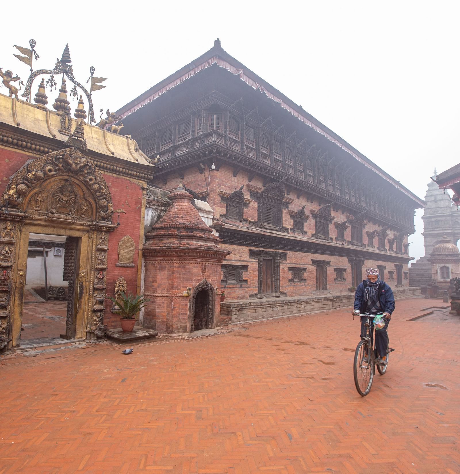 A facade view of the 55 window palace with golden gate in front of which a man is riding his bicycle