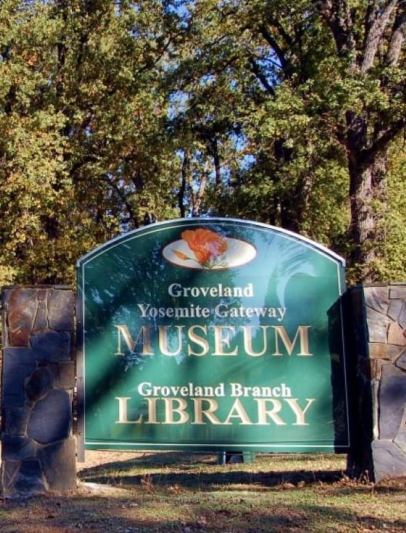 A sign reading Groveland Yosemite Gateway Museum and Groveland Branch Library - The Groveland Hotel.