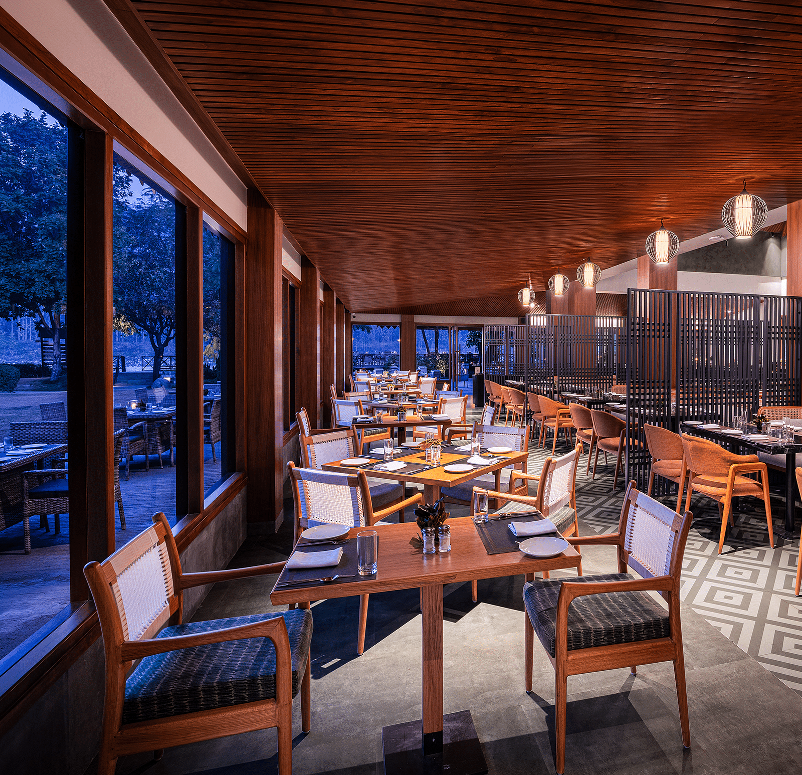 An image of a dining area with several chairs and table at one side and sofa sets on the other side - The Riverview Retreat,  Corbett