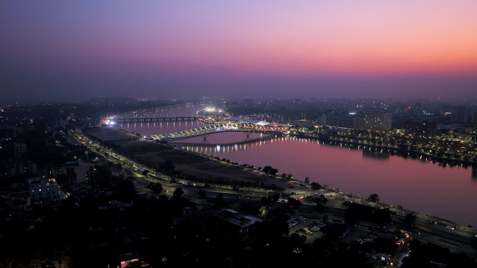 Sabarmati Riverfront sunset view with Atal Bridge illuminated and Ahmedabad skyline