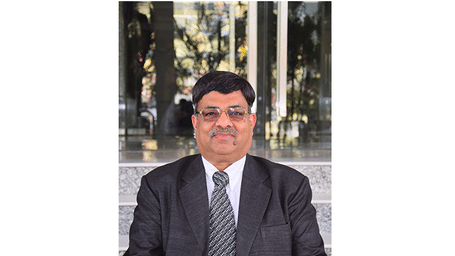 Headshot of a businessman, likely a hotel executive, wearing a dark suit, white shirt, and striped tie.