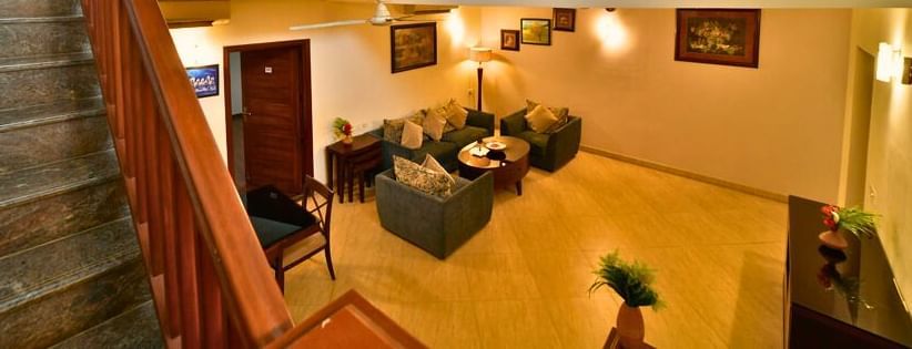 A staircase leading to another level of the Aqua Bungalow at Vedic Village Spa Resort featuring a glimpse of the living rooms.