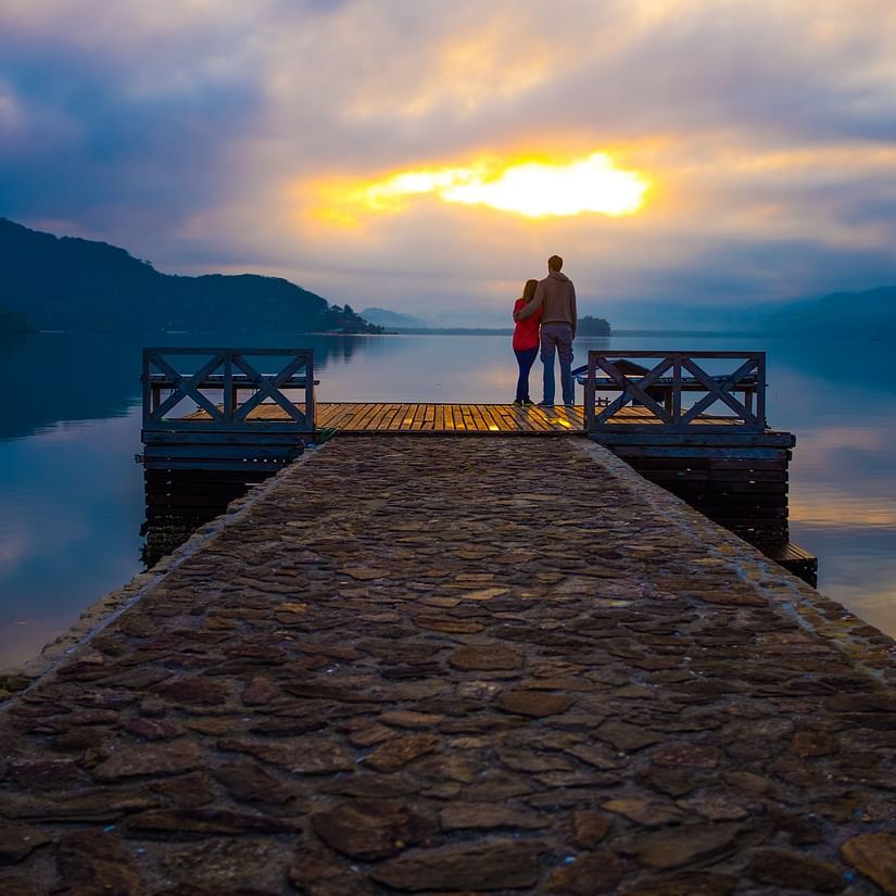 A couple enjoying the sunset from a jetty