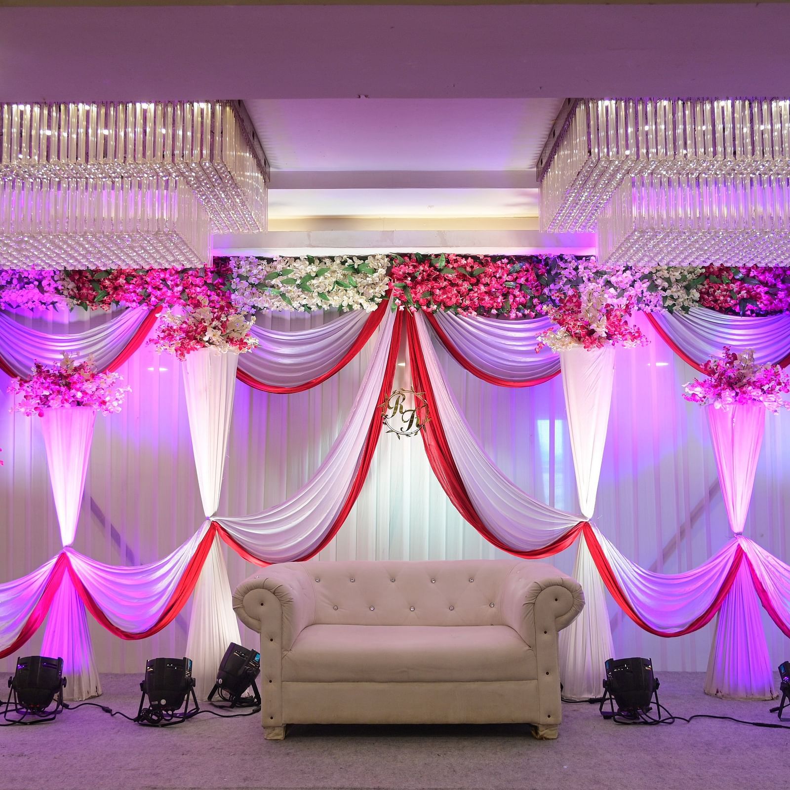 Wedding or event stage decoration with colorful drapes and a white armchair at Rang Lords Inn Bharuch