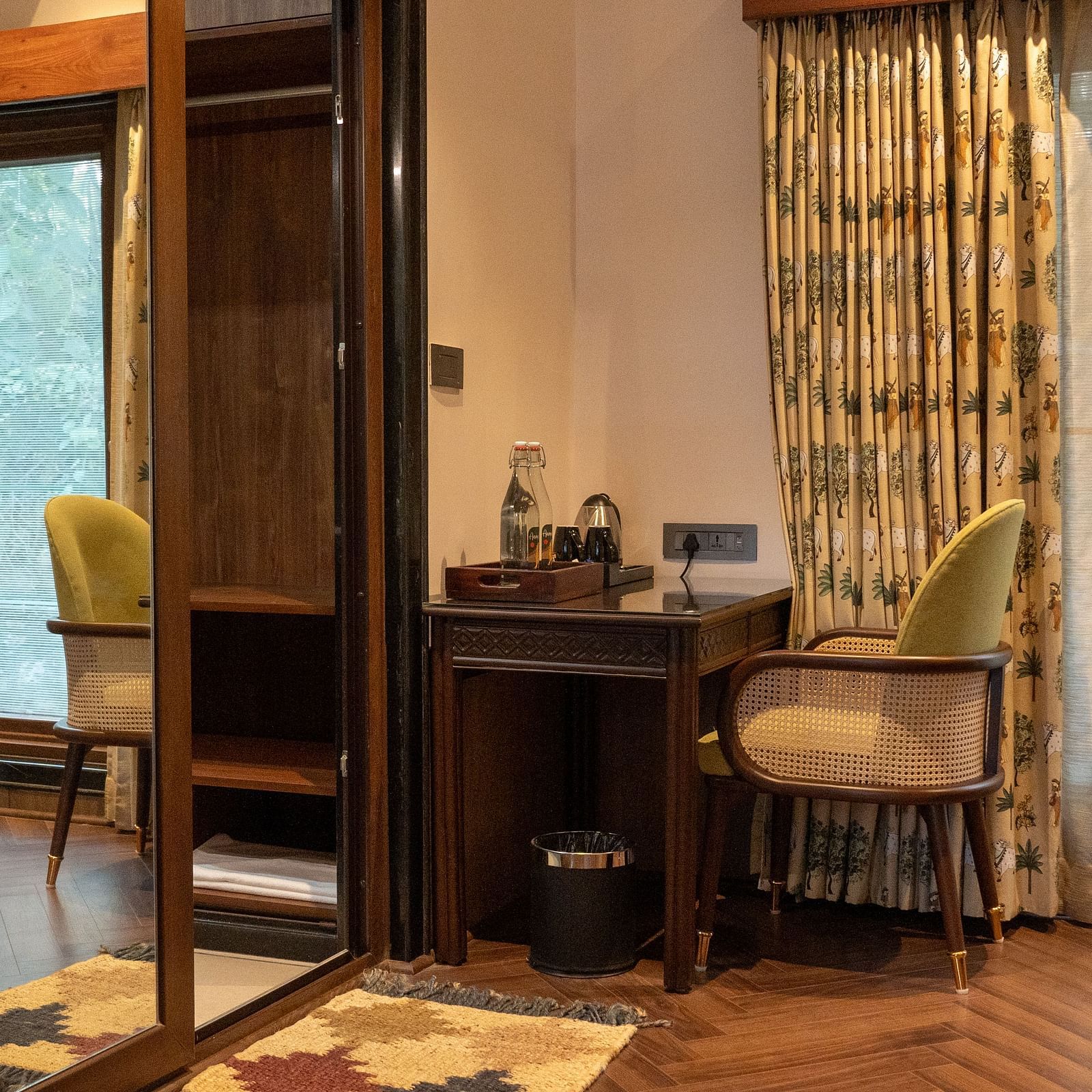 A cosy corner in a room at Aamaghati Jungle Retreat Ranthambore with a desk and chair by a window.