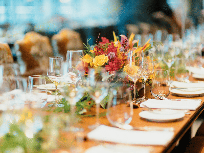Stylish banquet table arrangement at Ramada Plaza by Wyndham Palm Grove with floral centrepieces, glassware, and neatly set plates for a formal event or celebration.