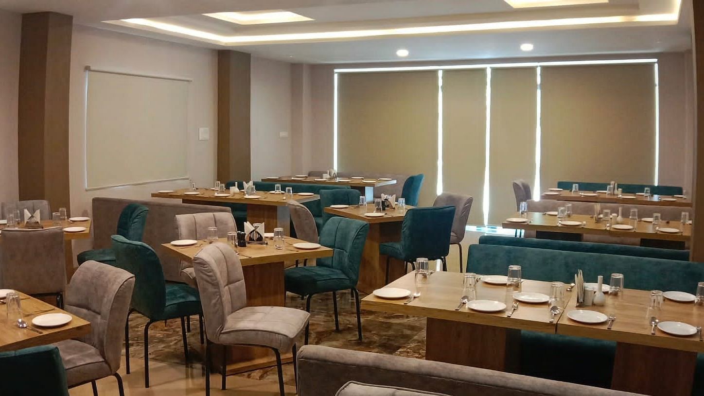 Dining area with blue and brown chairs at Hotel Mumbai House, Indore