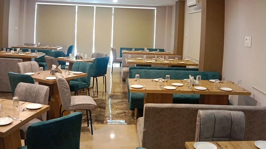Image of dining area with sitting chairs and tables at Hotel Mumbai House, Indore