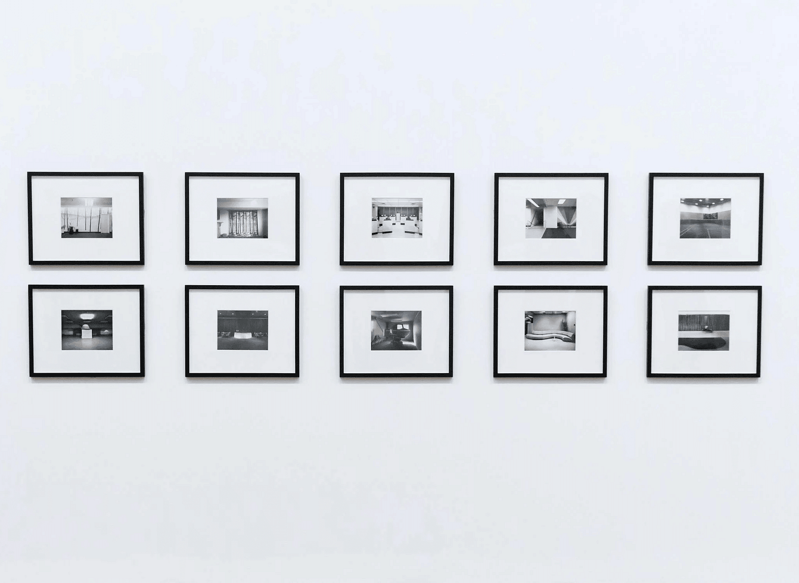 Bunch of photoframes hanged on a white wall.