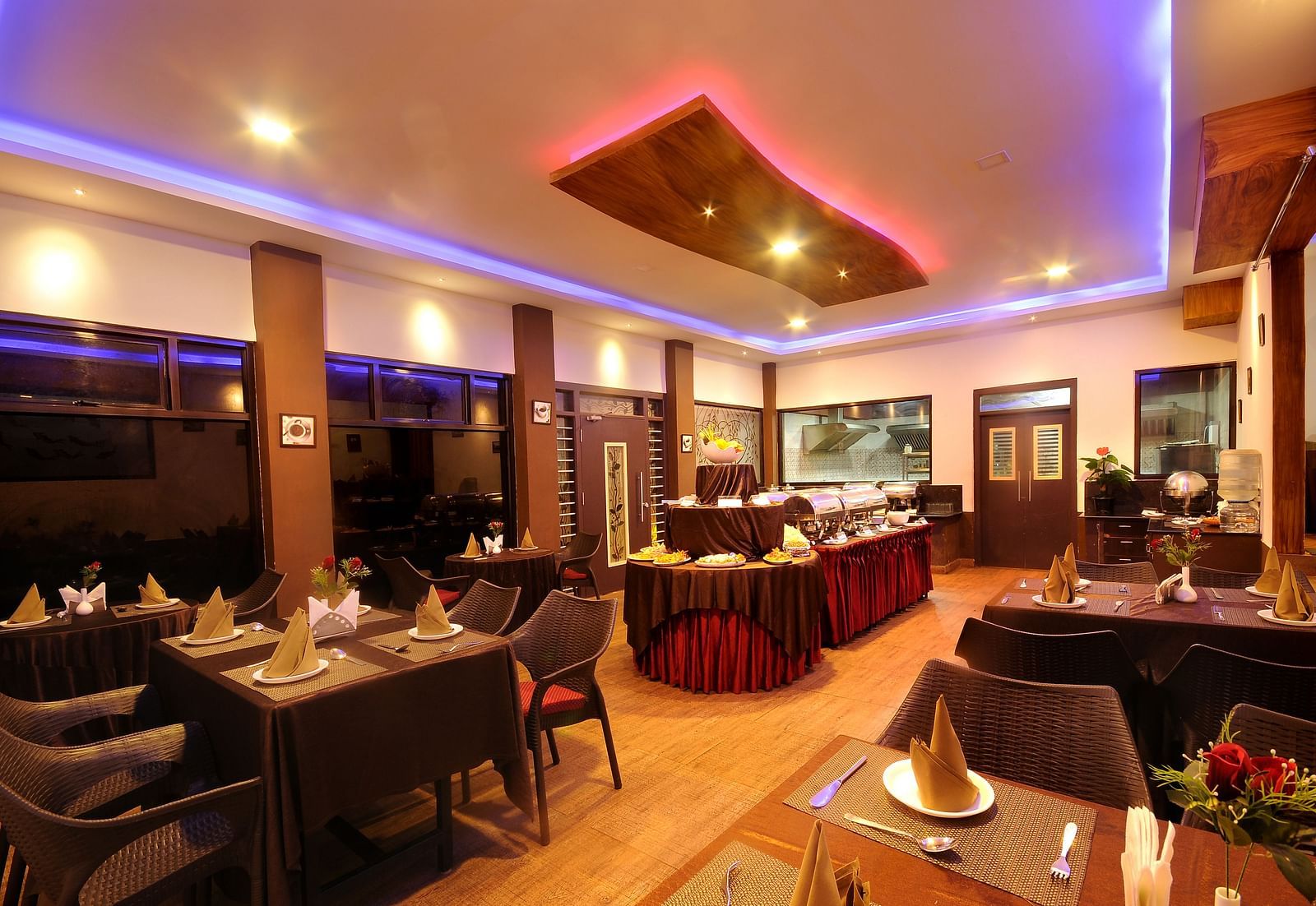Image of a dining space with tables and chairs and lights on the ceiling at Parampara Resort & Spa, Kushalnagar.