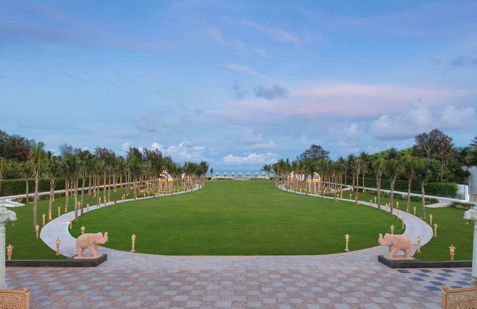 An outdoor lawn in Mahabalipuram surrounded by lush greenery and offering views of the sea – Kaldan Samudra Palace, one of the premier Outdoor Lawn Wedding Venues in ECR