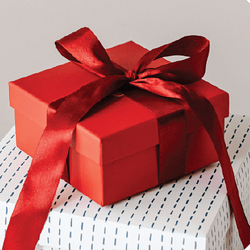image of a red gift box with a silky red ribbon tied around it