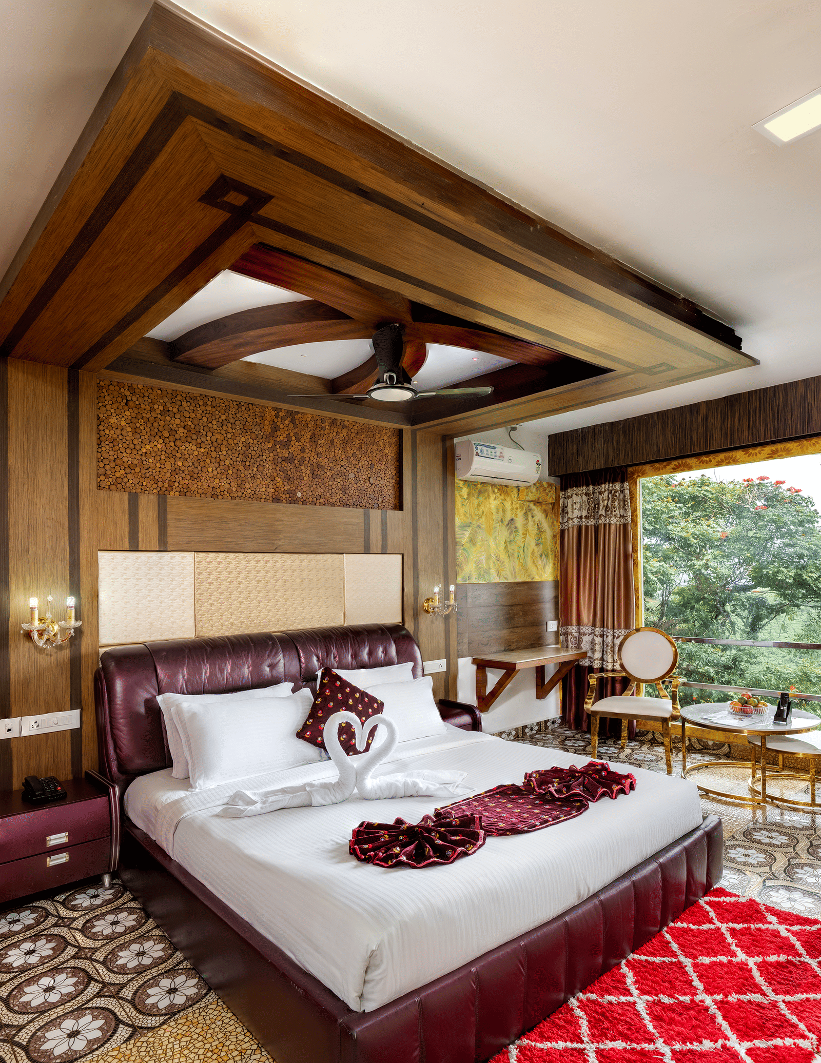 A sleeping area in the Double Bedroom Pool Villa at Parakkat Nature Hotel and Resorts, Munnar, featuring decorative wood ceiling work, a large bed, and expansive windows overlooking the landscape.