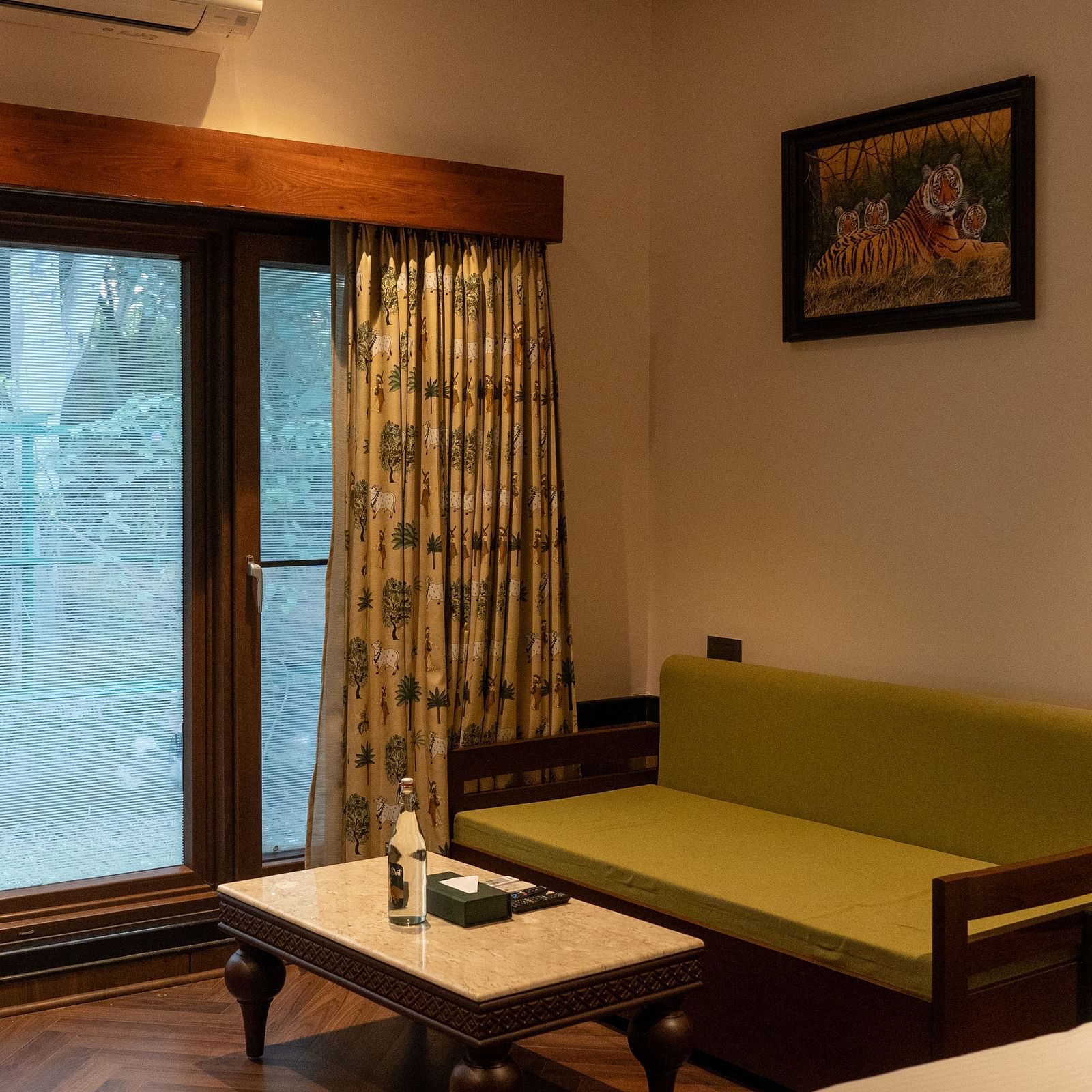 A comfortable living area in a guest room at Aamaghati Jungle Retreat Ranthambore with a sofa and coffee table.