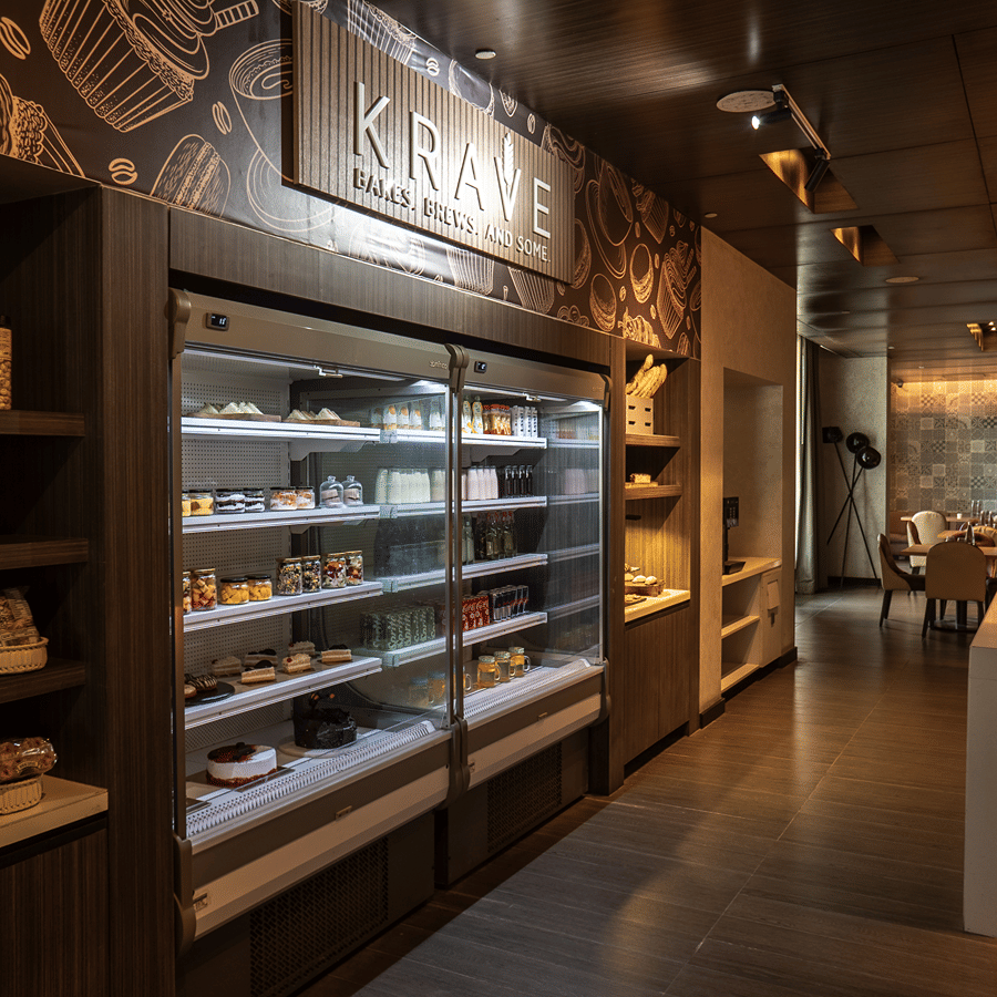 View of the grab-and-go station, showing shelves filled with a variety of snacks, drinks, and fresh food at The Residency Towers Rameswaram.