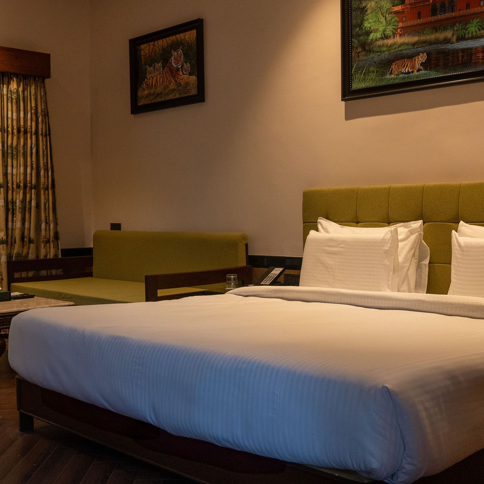 A spacious bedroom at Aamaghati Jungle Retreat Ranthambore with a large bed and a seating area.