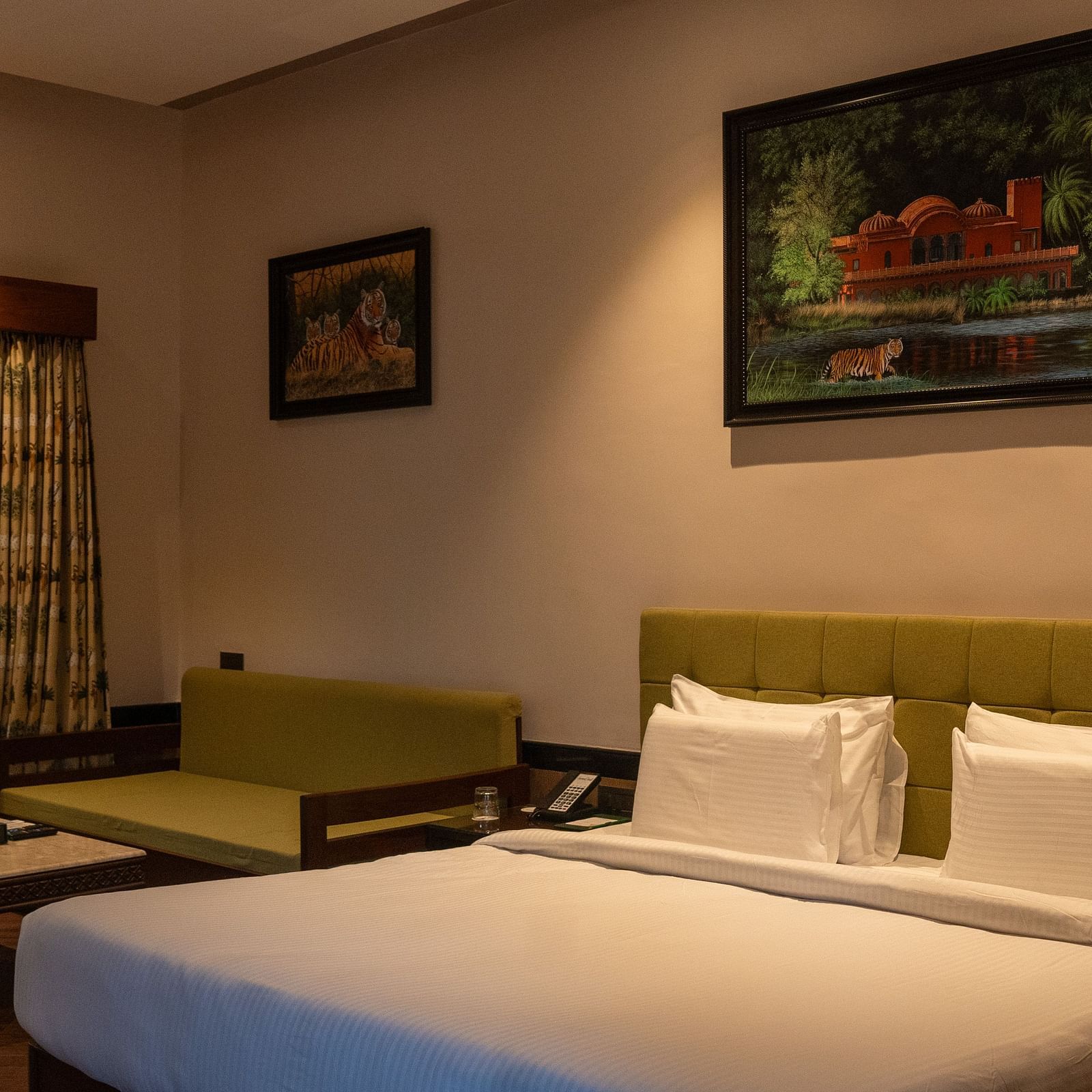 A comfortable bedroom at Aamaghati Jungle Retreat Ranthambore featuring a large bed and tasteful art.