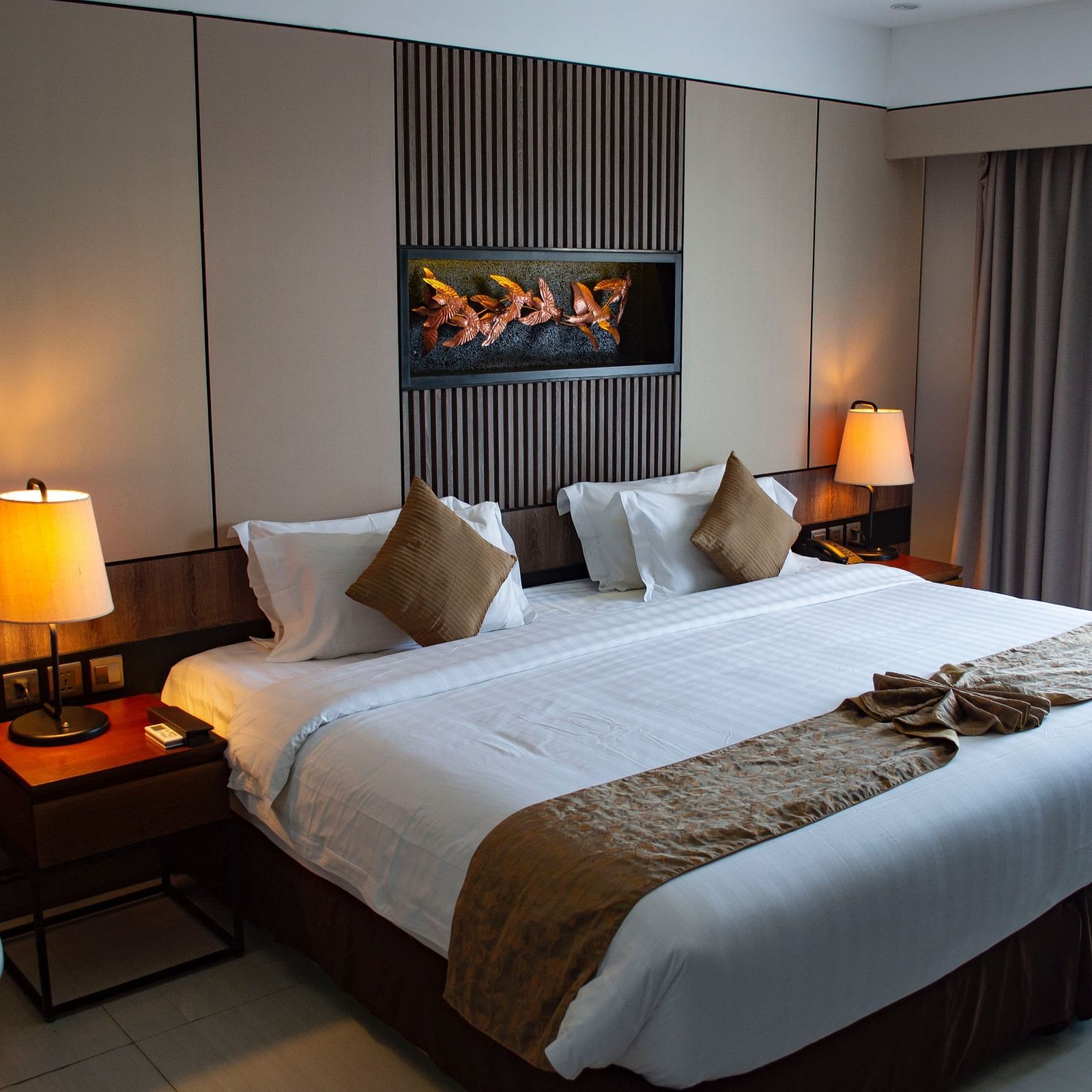 A double bed with side tables and lamps on either side of it