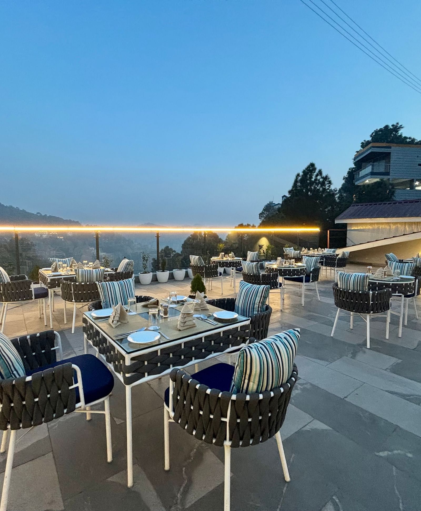 Outdoor dining area at twilight with neatly arranged tables and scenic views – ARNISA Boutique Hotel
