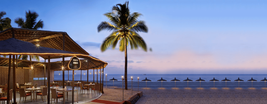 An elegant beachside restaurant with an open-air seating area, offering stunning ocean views and a tranquil dining experience.