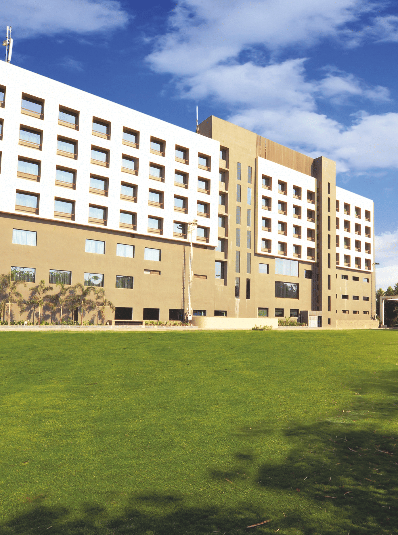 Exterior view of hotel building with expansive lawn – Narayani Heights Hotel & Resorts