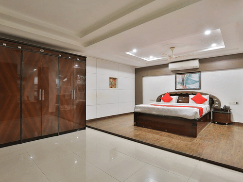 An overview of the Premium Suite with a king bed, a wall mounted AC, side tables and a large wardrobe in view at VITS Select, Bharuch.