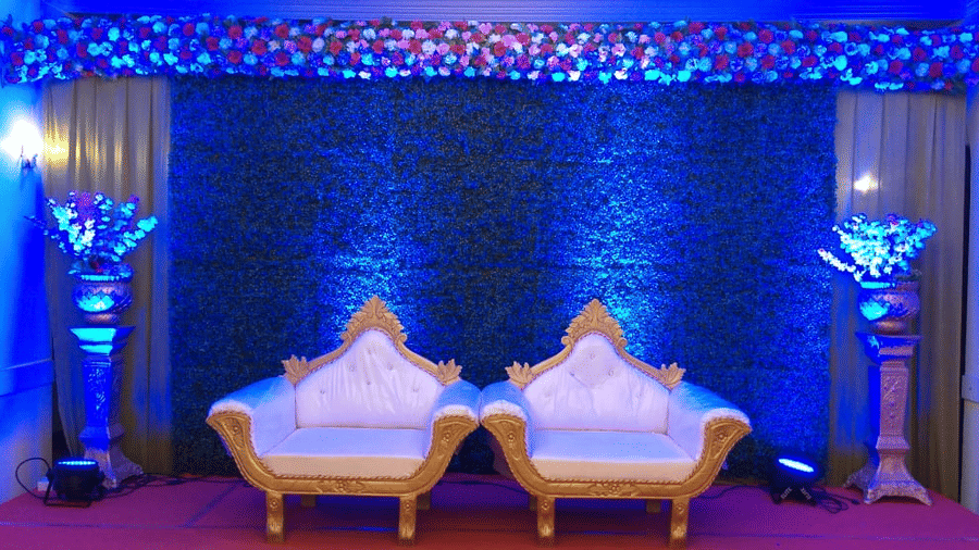 a decorated podium at the event hall with 2 seats for the couple - Zara's Resort