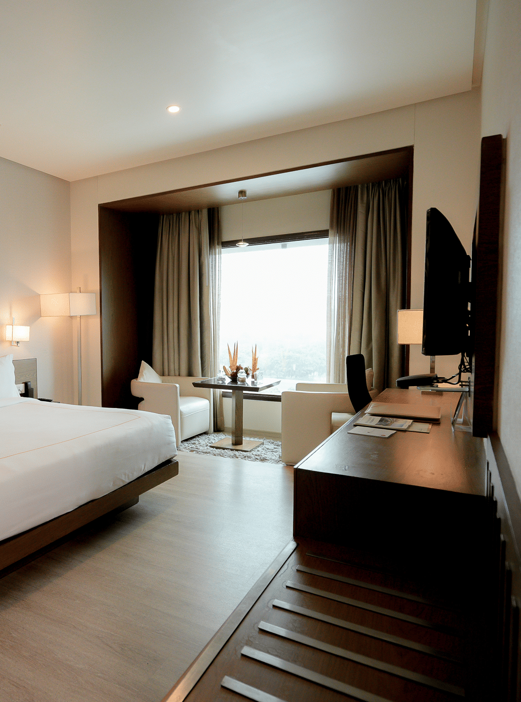 Spacious hotel room with modern furnishings and natural lighting – Narayani Heights Hotel & Resorts