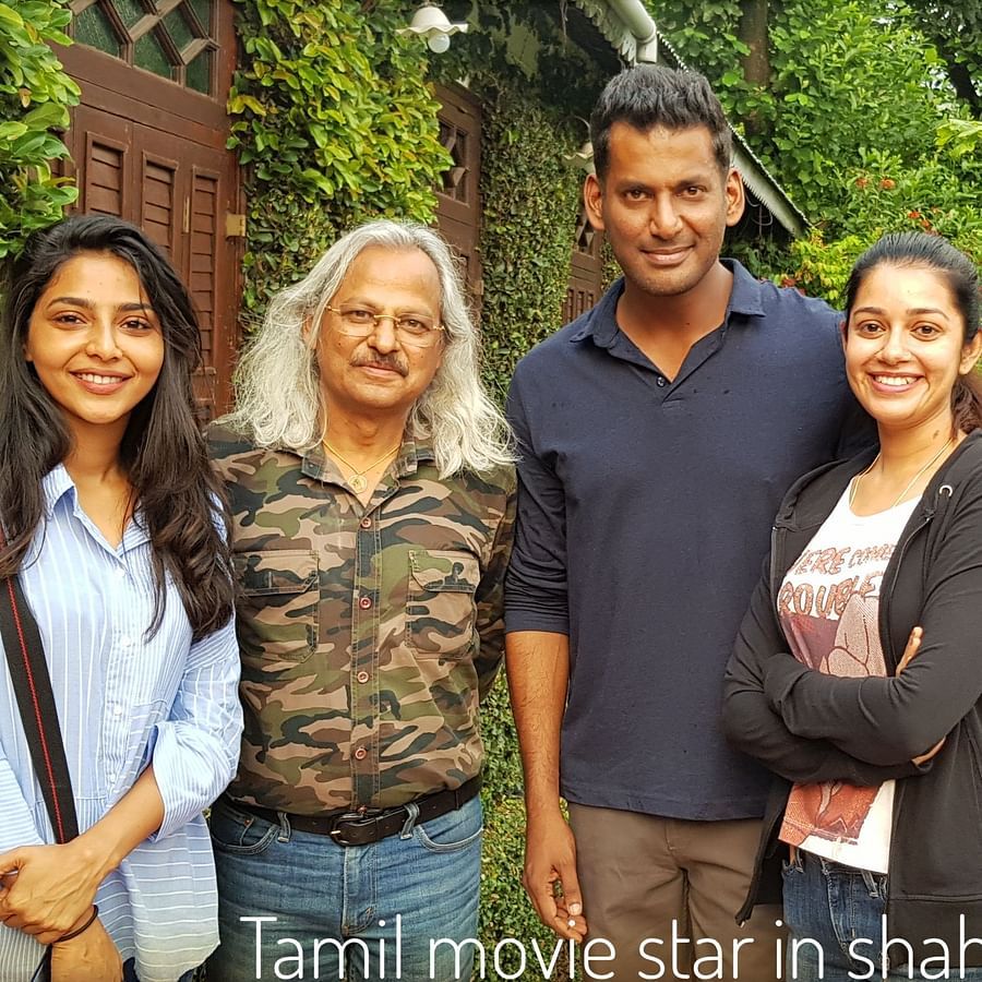 Image of  group of people posing for a picture with greenery behind them
