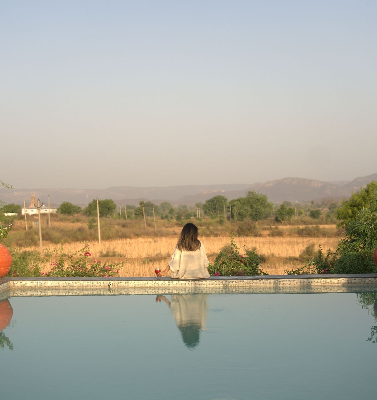 An image of a women sitting near a pool