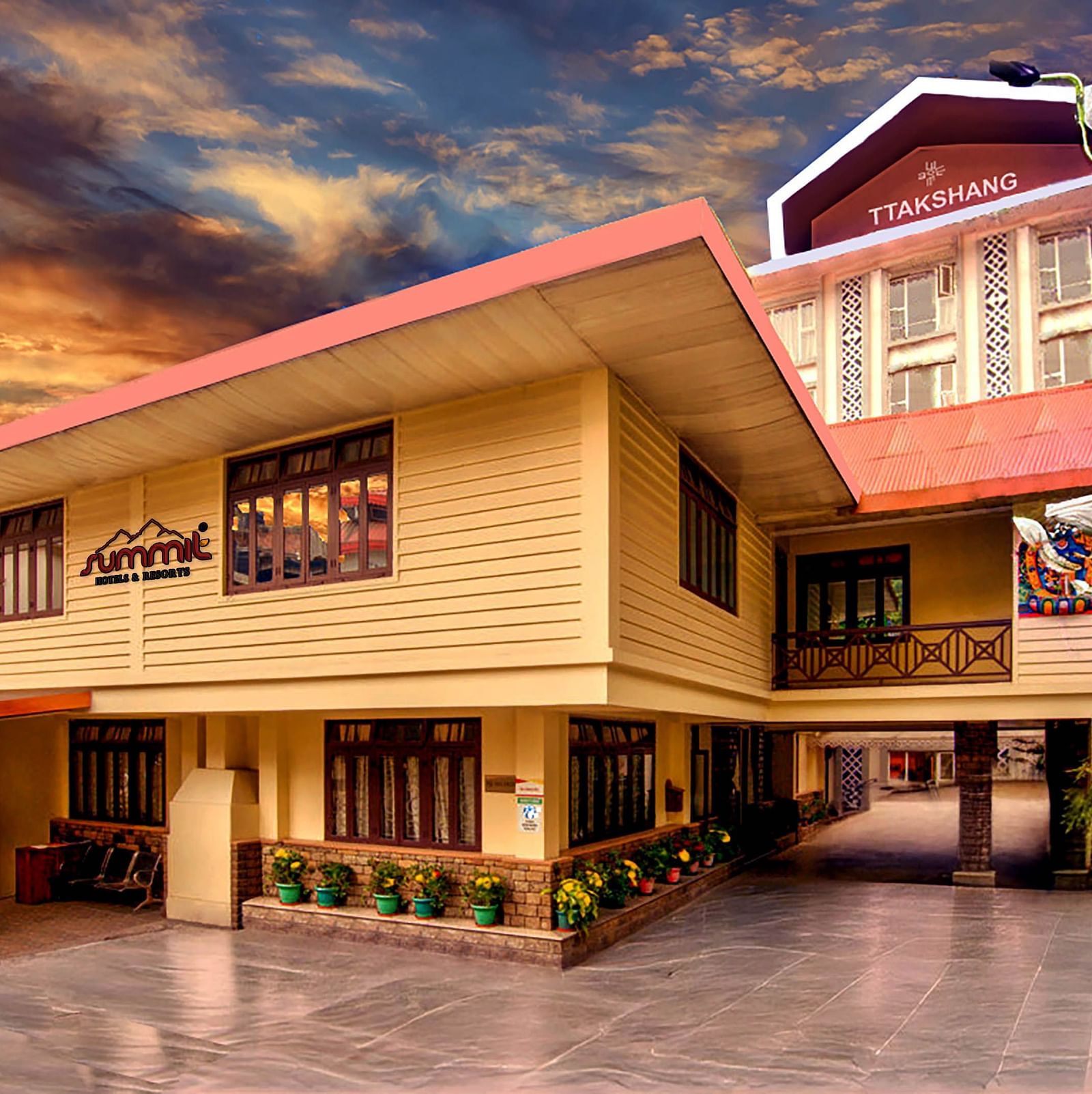 Facade of Summit Ttakshang Residency Hotel & Spa, Gangtok, with a sunset-lit cloudy sky and trees lining the pathway