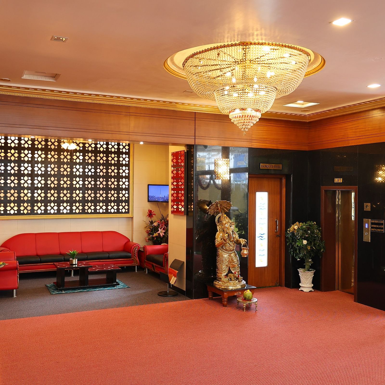 Image of the Lobby of The Grand Krishna Rooms, Bengaluru featuring a beautiful chandelier hanging from the ceiling