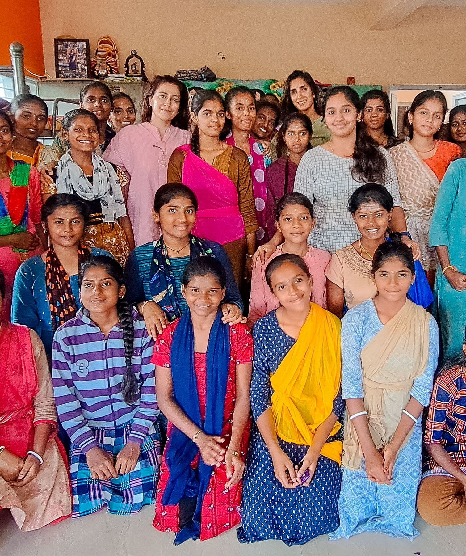 Group of people in colorful clothing posing for a photo, indoor setting - Shreyas Retreat