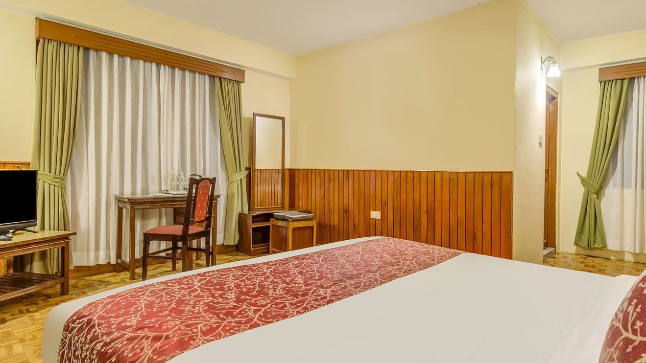 Image of a room with bed and a television in front at Summit Tashi Ghang Heritage Resort, Pelling