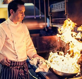 An image of a man wearing chefs uniform cooking in a kitchen The Earl s Court Nainital zjigpl