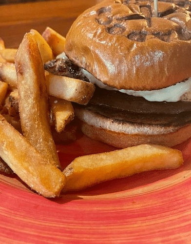 a close up shot of a hamburger complemented with potato french fries served on a crimson plate at Tapoco Tavern - Historic Tapoco Lodge 