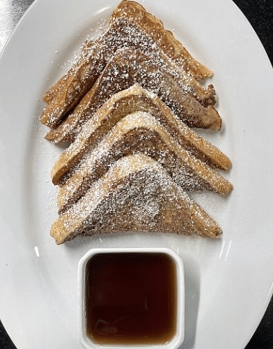 a mouthwatering serving of the french toast with powdered sugar drizzled over it - Historic Tapoco Lodge