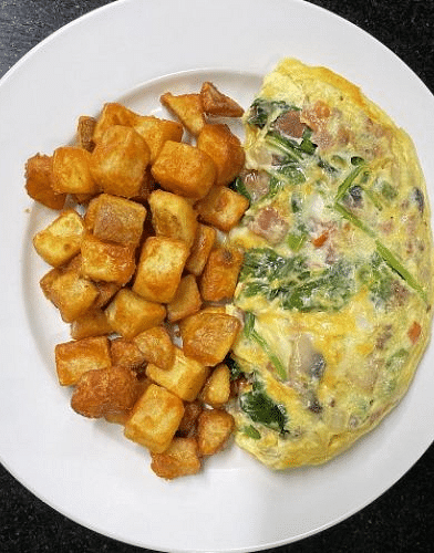top angle view of a fluffy omelette served with diced potatoes - Historic Tapoco Lodge