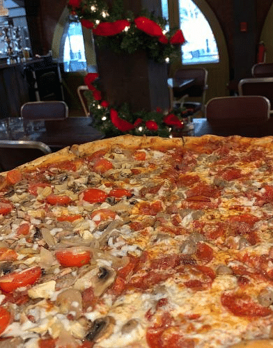 a close up image of a huge pizza with a lot of pepperoni -  Historic Tapoco Lodge 