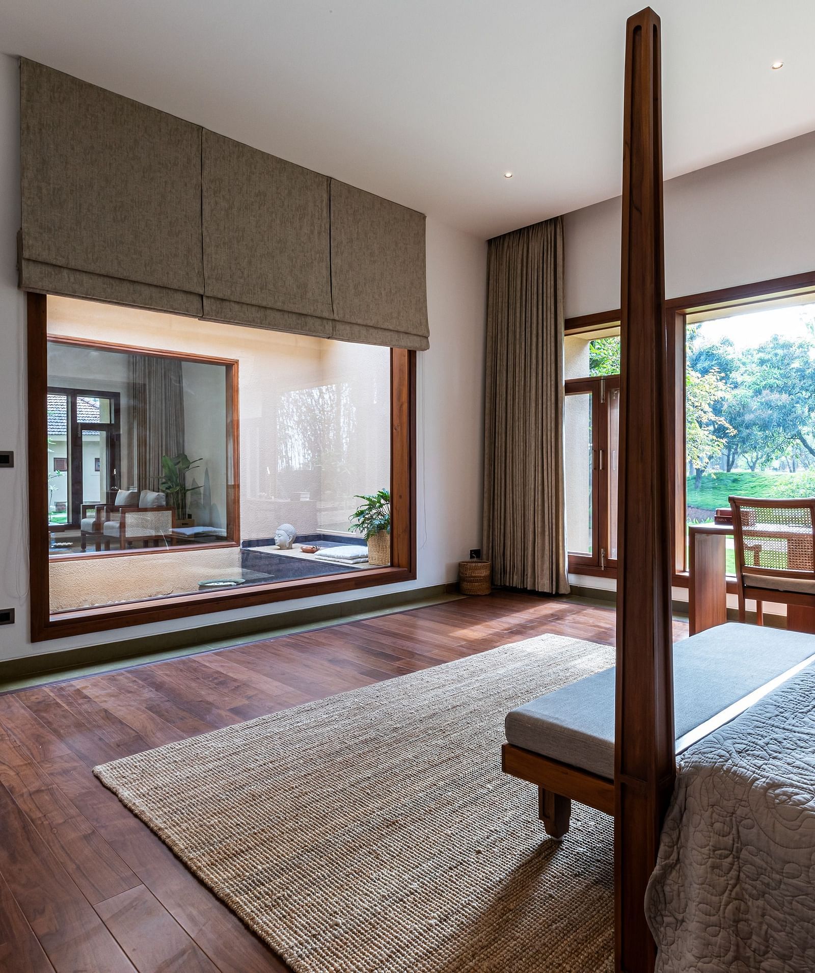 Bedroom with a wooden bed, large windows, rug, indoor space - Shreyas Retreat