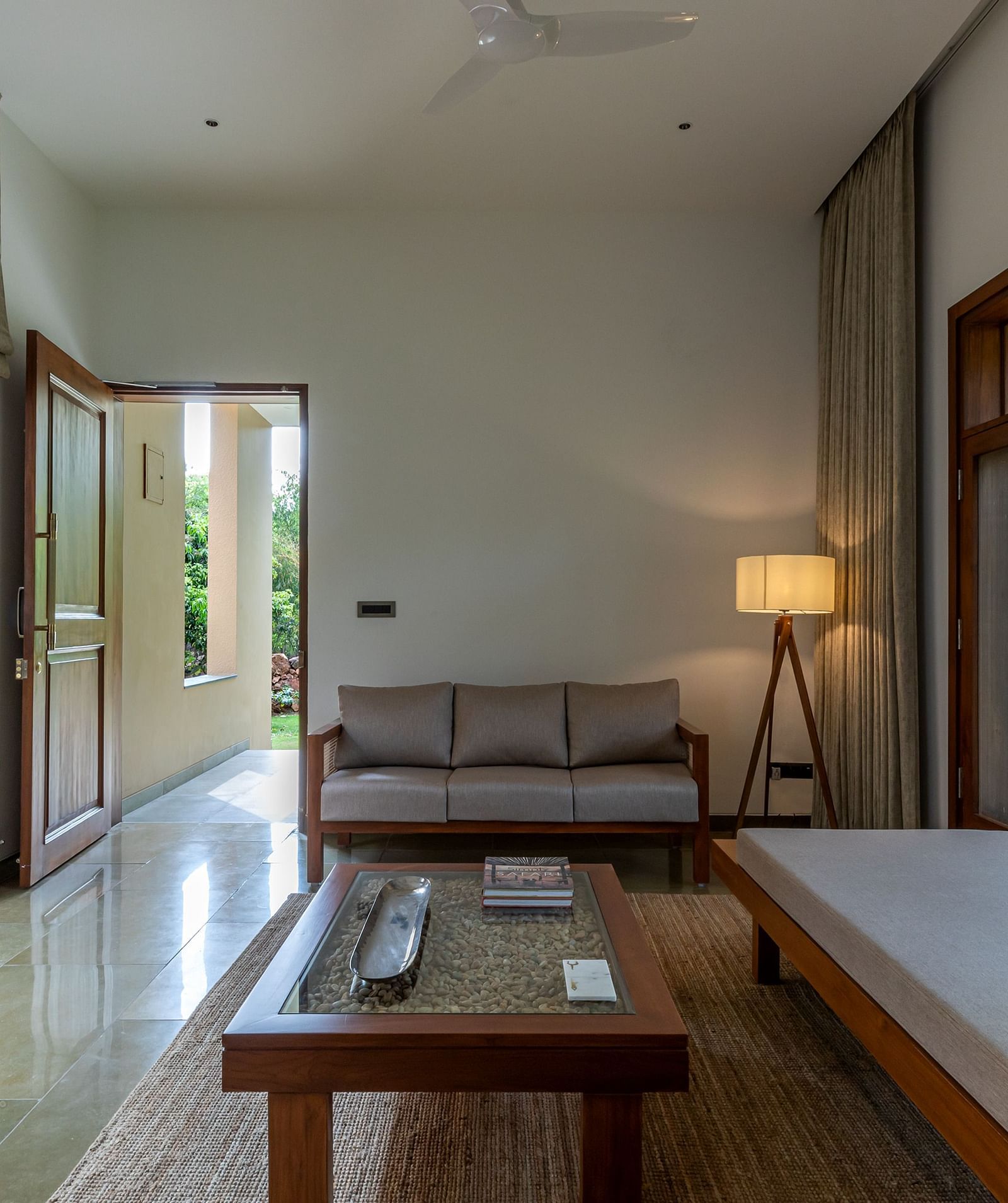 Interior room with a bed, couch, and lamp, minimalist design, natural light from windows - Shreyas Retreat