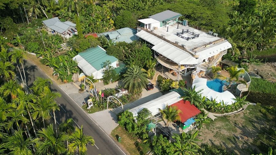 An aerial view of Matsya Island Retreat by Island Quest, showing buildings, a pool, and lush greenery.