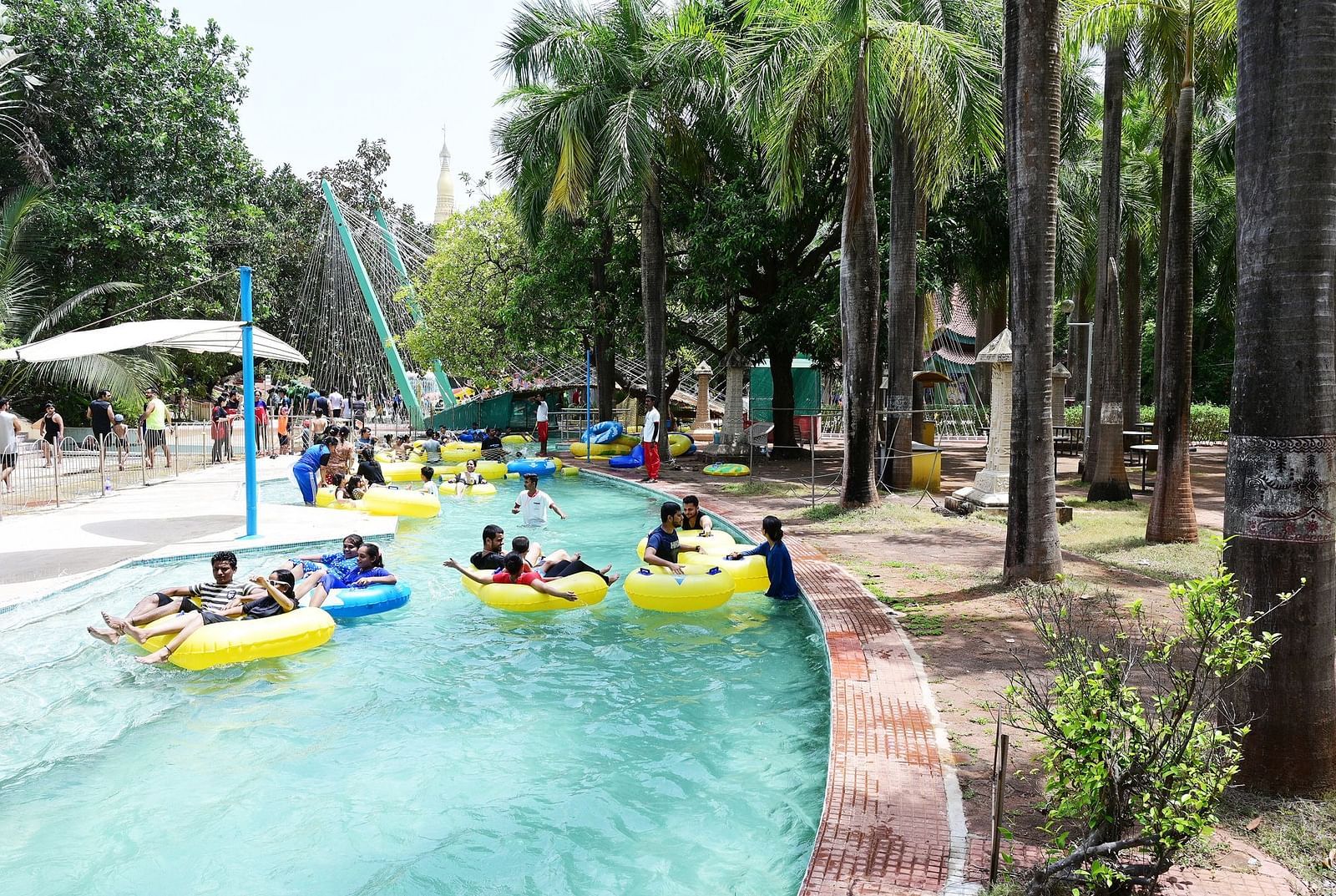 An image of the Lazy River at Water Kingdom where group of people are seen enjoying themselves in the water with tubes around their waist