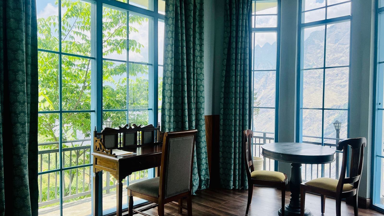 Two large windows adjacent to each other and a sitting area near it | Faraway Cottages, Auli