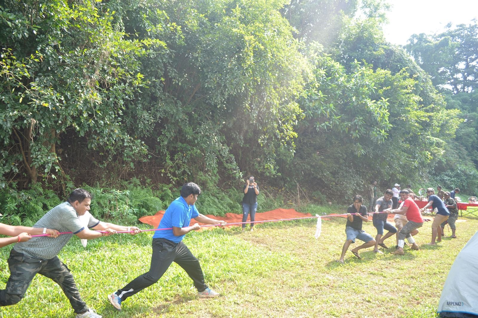 Outdoor activities at Forest Escape include a lively tug-of-war competition amidst the lush greenery.