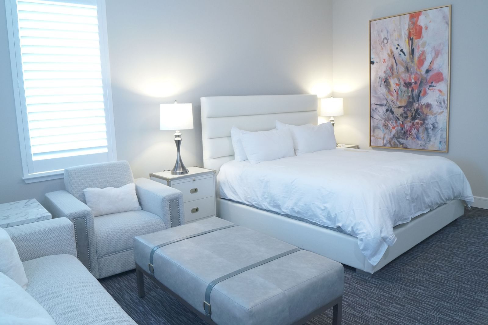 A stylish bedroom featuring a large bed, soft lighting, and minimalist furniture, designed for a comfortable stay - The Grand Hotel & Ballroom, McKinney