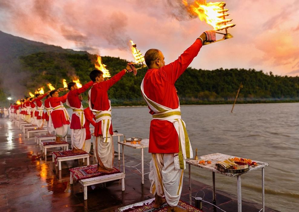 An image of People performing Aarti on the River bank, captured in the evening.