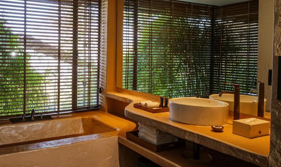 A large bathroom with huge mirror and window covered by blinds | Kavya Resort and Spa, Nagarkot