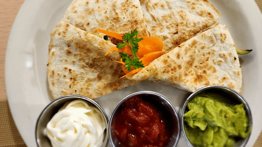 Close-up of quesadilla with salsa, sour cream, and guacamole trio - Hotel 39, Jamaica