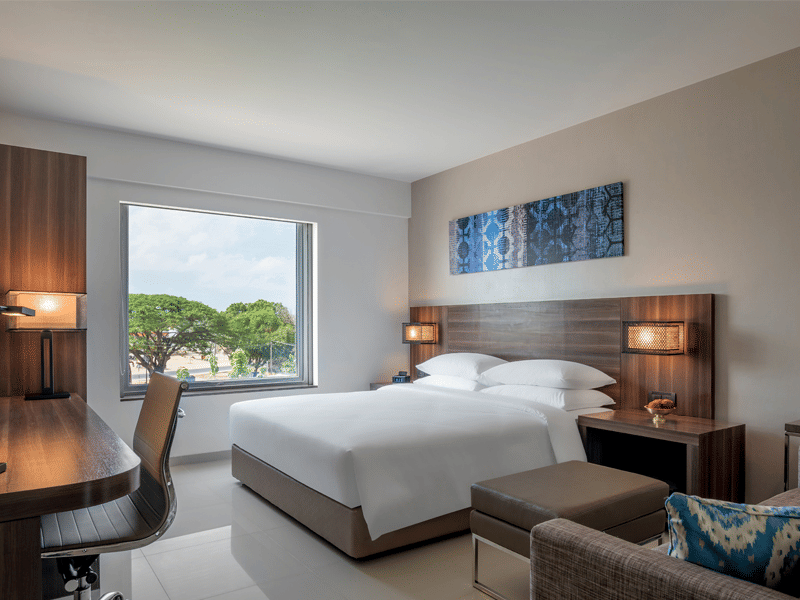 Standard king room featuring a bed, couch, television and a working area at The Residency Towers Rameswaram